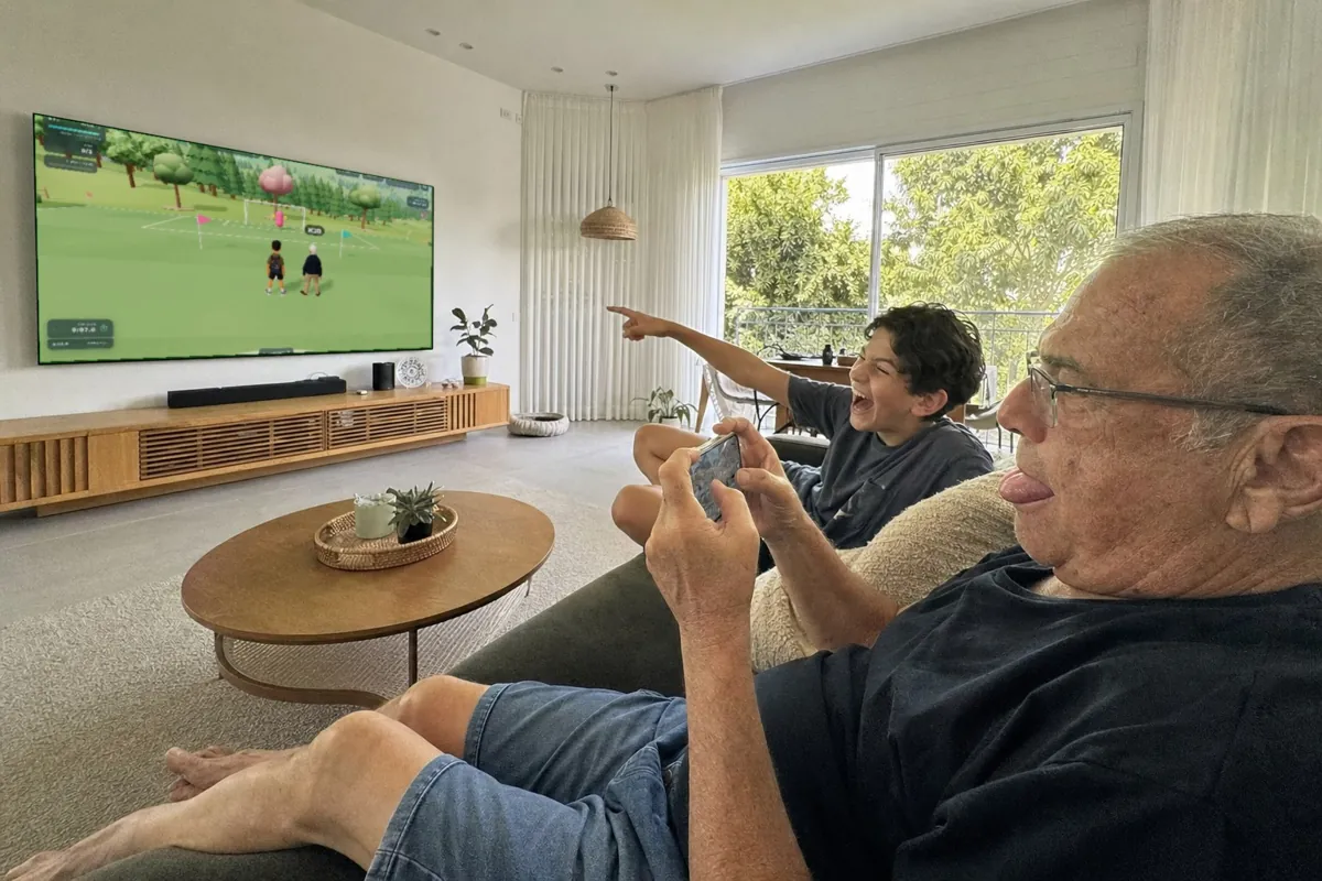 Grandpa playing the personalized bar mitzvah video game with his grandson