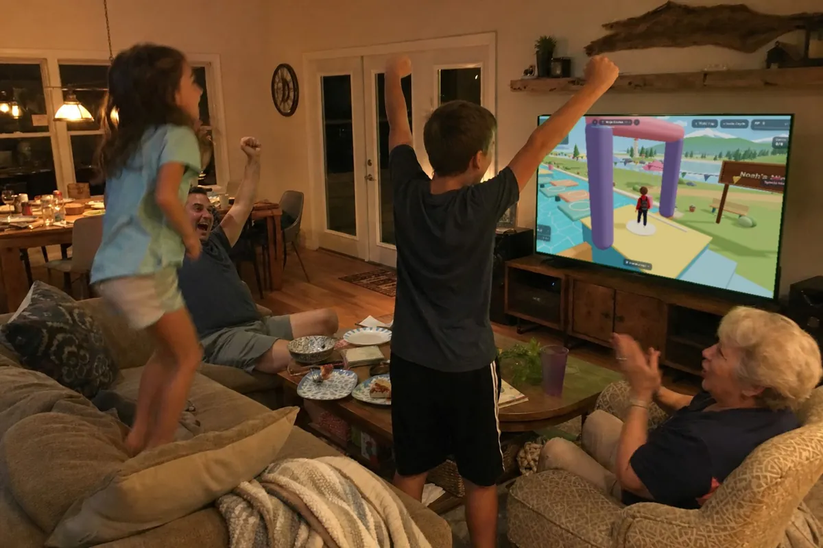 Family cheering as the kid plays his personalized game on the TV